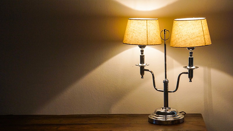 Bild einer angeschalteten Stehlampe mit 2 Lampenschirmen.